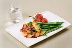 Grilled fish with roasted potatoes, green beans, and tomatoes
