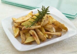 Plate of roasted parsnip fries garnished with rosemary.