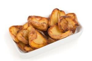 Crispy roasted potato wedges in white rectangular dish