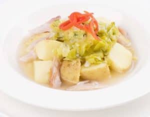 Bowl of boiled potatoes with cabbage and sliced peppers
