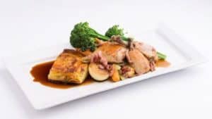 Plated gourmet meal with roasted meat, vegetables, and sauce