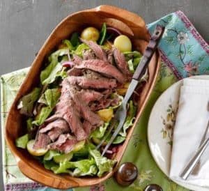Sliced steak salad with mixed greens and grape tomatoes