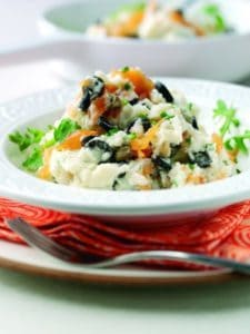 Creamy vegetable risotto served in white bowls with herbs