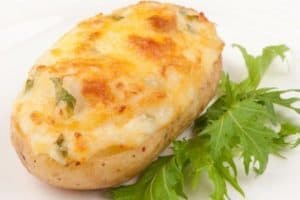 Half baked potato stuffed with cheese and herbs garnish