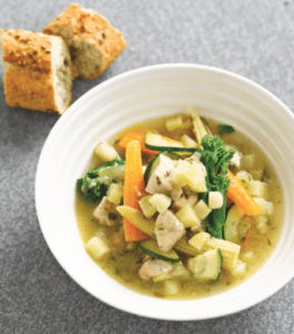 Bowl of homemade vegetable and chicken soup with bread