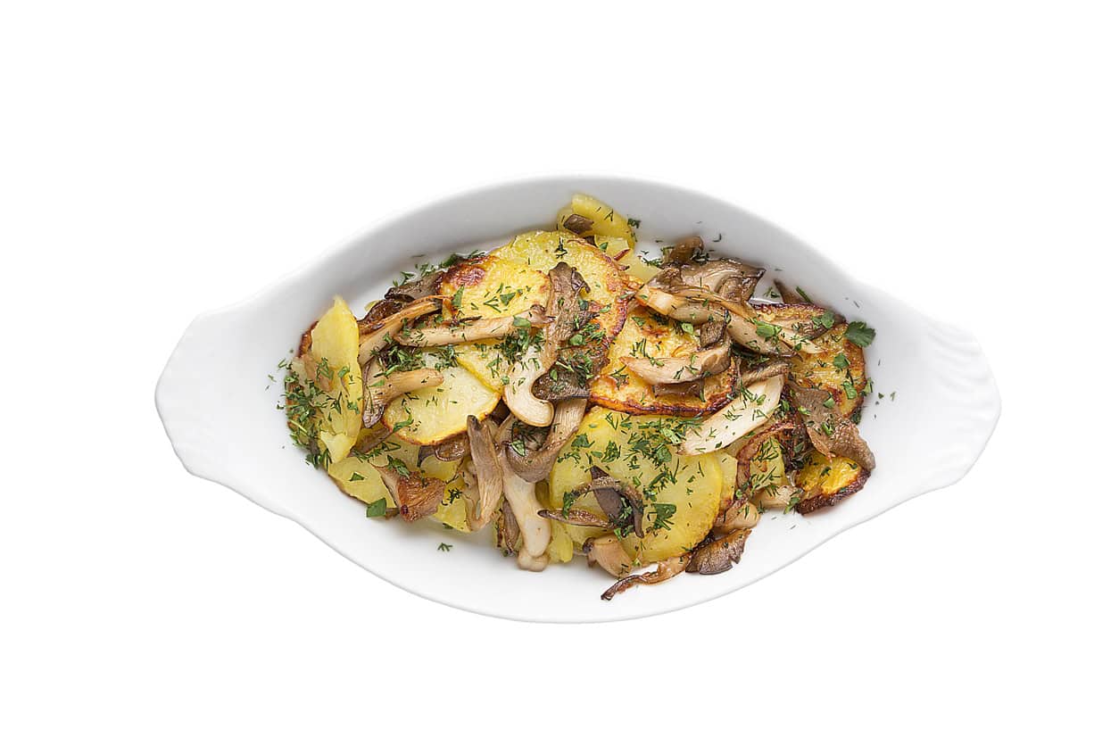 Appetizing dish of fried potatoes with mushrooms. Restaurant service concept.