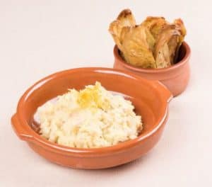 Mashed potatoes with roasted potato wedges in bowls