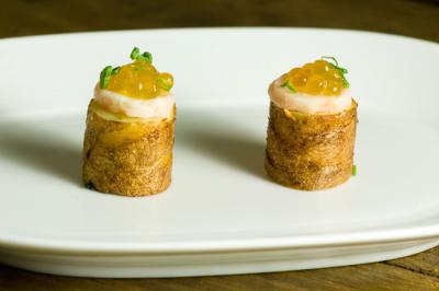 Two gourmet appetizers topped with sauce and garnish