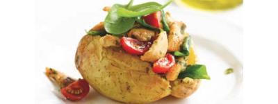 Baked potato topped with vegetables and cherry tomatoes