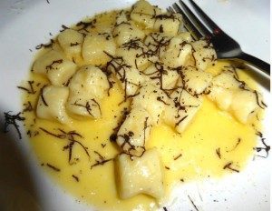 Plate of gnocchi in creamy sauce with herbs and fork