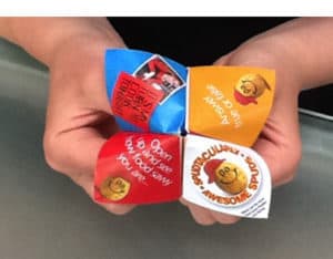 Hands holding a colorful paper fortune teller game toy