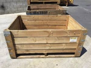 Large empty wooden crate with metal reinforcements outdoors