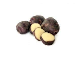 Purple potatoes whole and sliced on white background