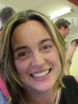 Smiling woman with blonde hair at indoor gathering
