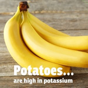 Bunch of ripe yellow bananas on wooden surface.