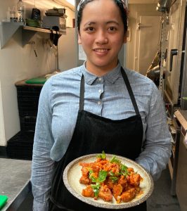 Plate of spicy fried chicken bites garnished with herbs