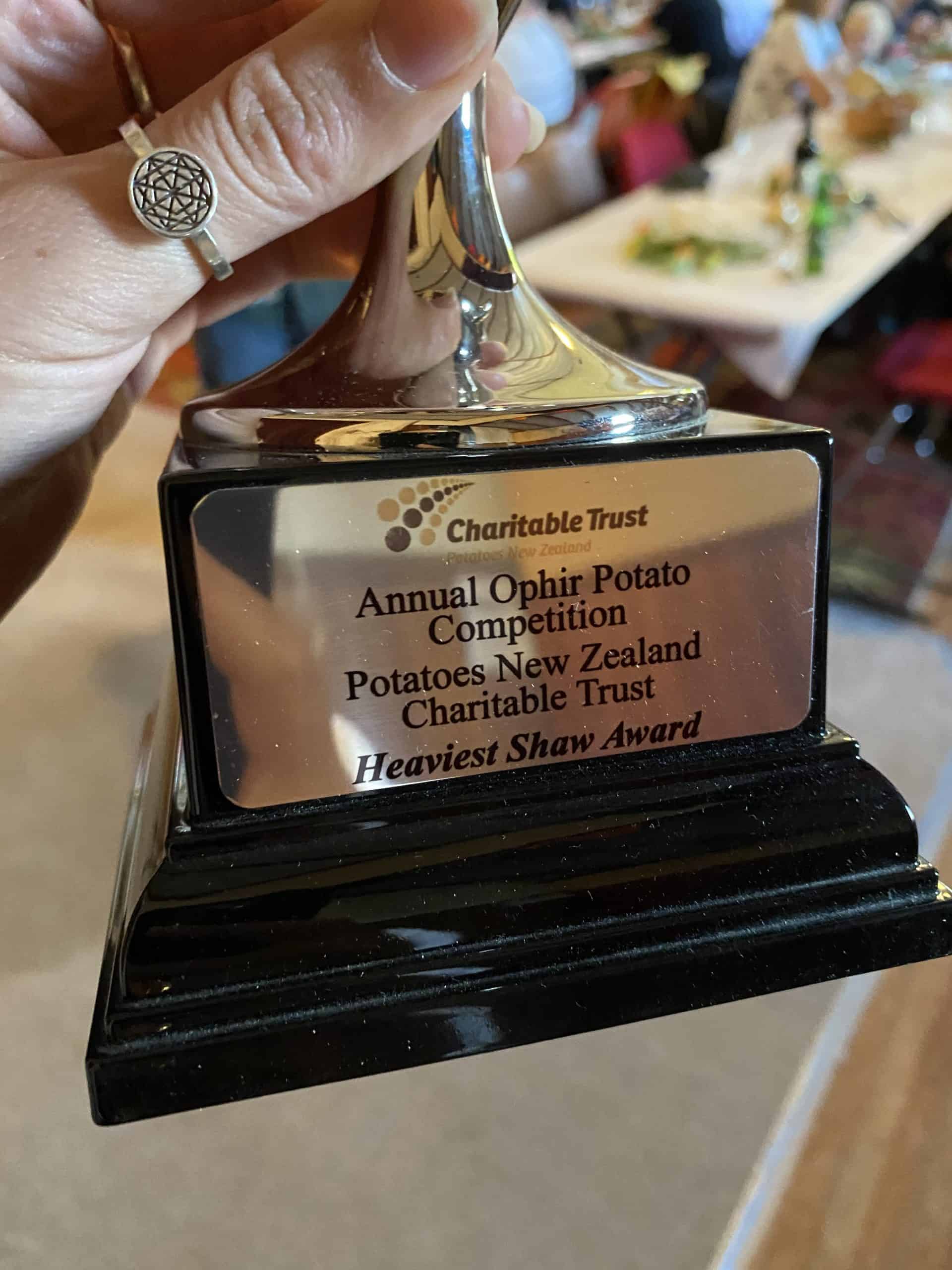Hand holding trophy for heaviest potato award at New Zealand competition