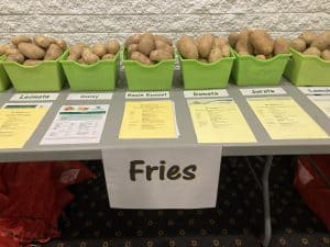 Variety of potato types for fries displayed in green bins