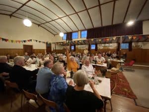 Community gathering in decorated hall with people enjoying event