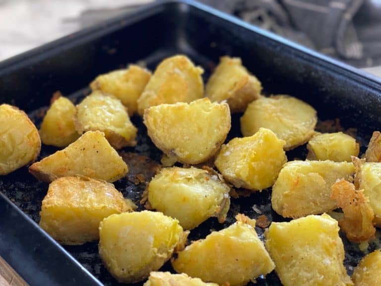 Crispy roasted potatoes seasoned with coarse salt on baking tray