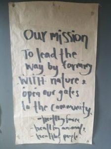 Handwritten mission statement on paper about farming and community.