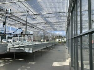Interior view of empty commercial greenhouse with metal tables