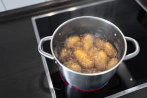 high angle view of pot with boiling water and potatoes on stove