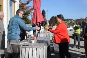 Outdoor group exchanging an item, social gathering scene.