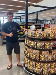 Man giving thumbs up near potato display in grocery store aisle