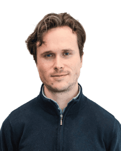 Young man with wavy hair wearing dark zip-up sweater
