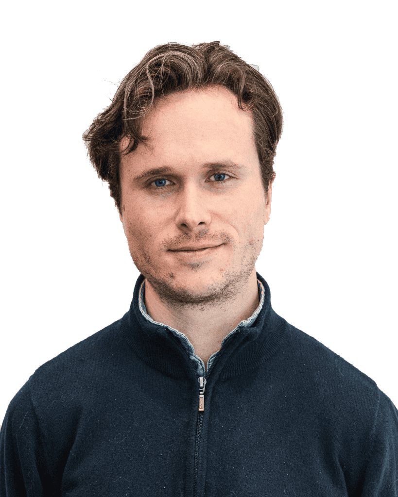Young man with wavy hair wearing dark zip-up sweater