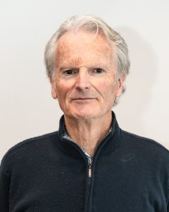 Senior man with gray hair wearing dark zip-up sweater