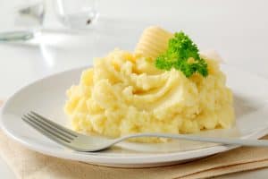 Close-up of mashed potatoes served on white ceramic plate