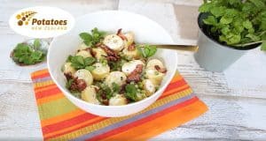 Potato salad with bacon, green peas, and fresh mint leaves