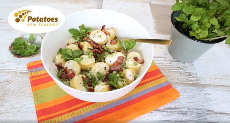 Potato salad with bacon, green peas, and fresh mint leaves