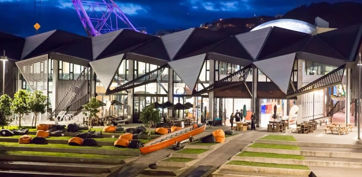 Modern outdoor seating area with bean bags and geometric roof design at night