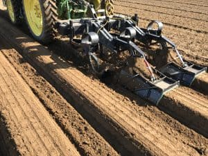 Tractor attaching precision farming equipment preparing soil beds.