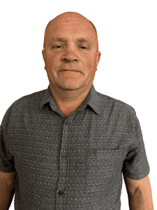Middle-aged man wearing a patterned short-sleeve shirt, looking forward
