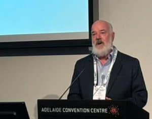 Man speaking at podium in Adelaide Convention Centre conference room