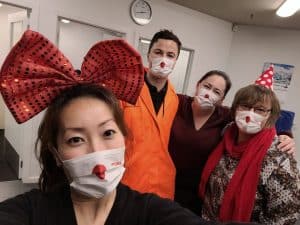 Group of people wearing face masks and festive party accessories indoors
