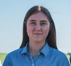 Young woman in checkered shirt outdoors on clear day