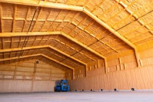 Warehouse interior insulated with spray foam and blue lift machine
