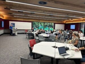 Group of people attending a presentation in modern conference room.