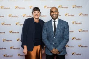 Two professionally dressed people smiling at Potatoes New Zealand event backdrop