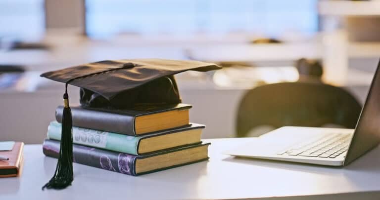 Graduation cap, books and laptop or university education for future goal, scholarship or online. Studying, research and thesis proposal for final school project for learning course, report or student