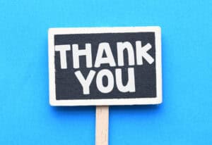 Black and white "Thank You" sign on blue background