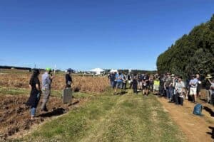 Group of people attending outdoor agricultural field day event