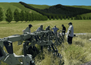 Group of people inspecting farming equipment in green field